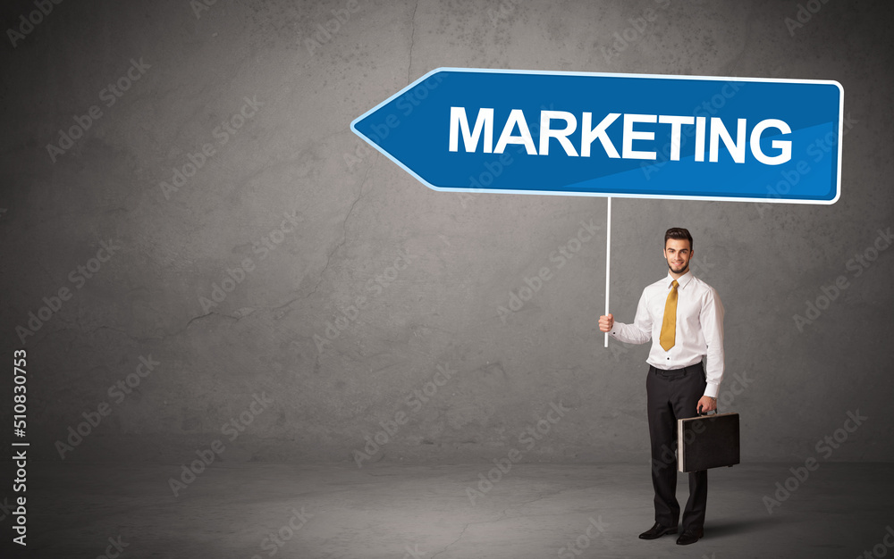 Young business person in casual holding road sign Young business person in casual holding road sign