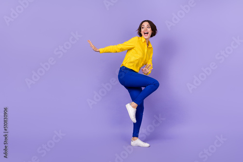Full length photo of funky young brunette lady dance wear shirt trousers footwear isolated on purple background
