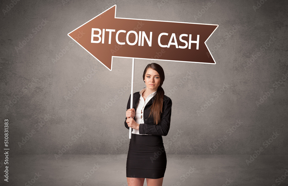 Young business person in casual holding road sign Young business person in casual holding road sign