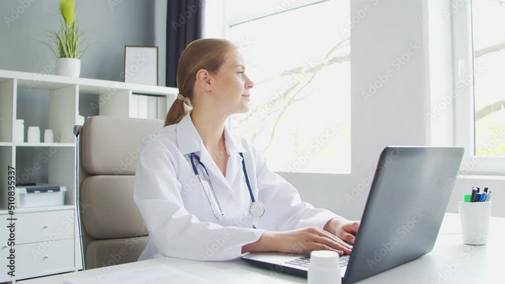 Doctor Works in the Medical Office. Woman in White Coat. Workplace of a Professional Female Therapist in a Hospital or Clinic. Healthcare and Medicine. Doctor Works in the Medical Office. Woman in White Coat. Workplace of a Professional Female Therapist in a Hospital or Clinic. Healthcare and Medicine.