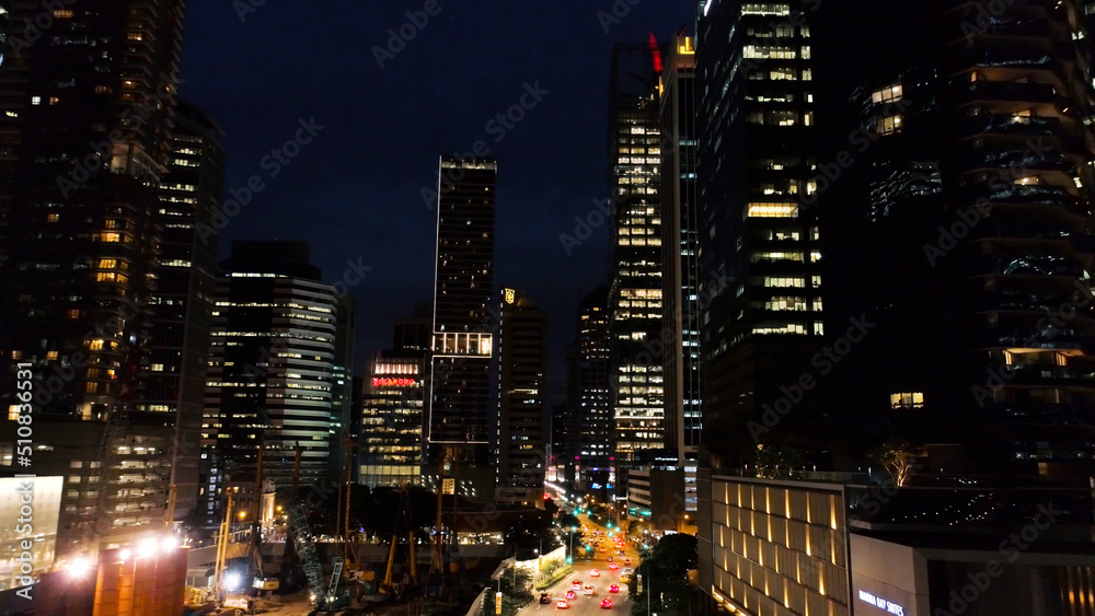 Exterior picturesque modern skyscrapers with glowing windows of offices in evening. Shot. The concept of nightlife in metropolis. Top view of offices of high-rise buildin in night