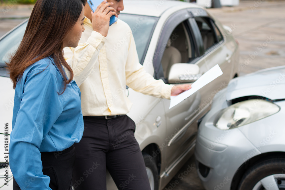 Two Drivers using a smartphone to exchange phone numbers and social media after a car accident. Concept of claim insurance for a car accident online after send photo and evidence to insurance company Two Drivers using a smartphone to exchange phone numbers and social media after a car accident. Concept of claim insurance for a car accident online after send photo and evidence to insurance company