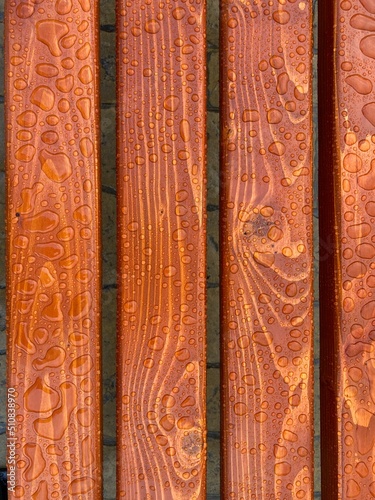 water drops on the wooden brown seat of a bench