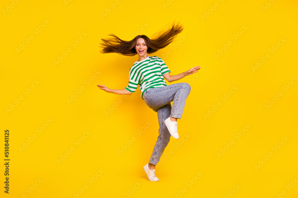 Full size photo of overjoyed pretty girl flying hairdo have good mood isolated on yellow color background Full size photo of overjoyed pretty girl flying hairdo have good mood isolated on yellow color background