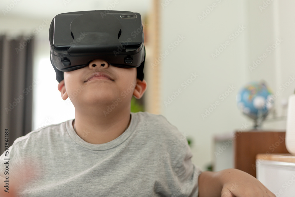 Asian Little boy with VR glasses studying sciences at home,curious student wears a virtual reality headset to study science home online study futuristic lifestyle learning Asian Little boy with VR glasses studying sciences at home,curious student wears a virtual reality headset to study science home online study futuristic lifestyle learning