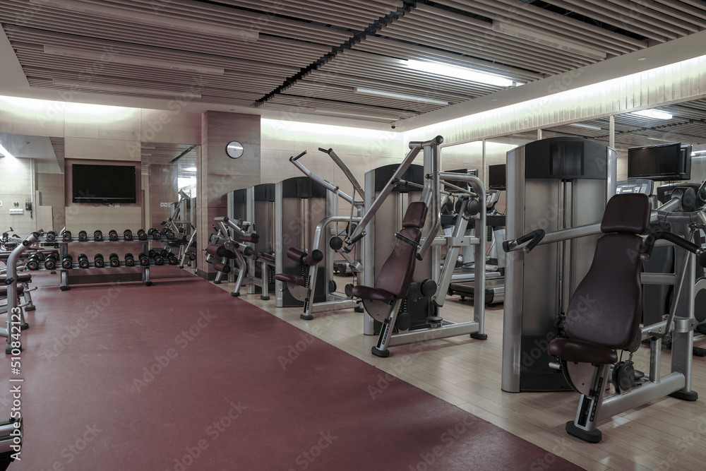 Modern light gym. Sports equipment in gym. Barbells of different weight on rack.	
