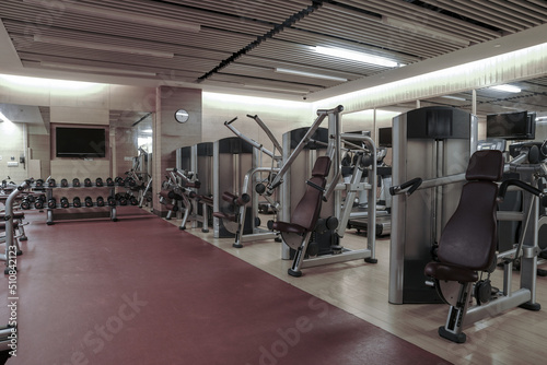 Fototapeta Naklejka Na Ścianę i Meble -  Modern light gym. Sports equipment in gym. Barbells of different weight on rack.	
