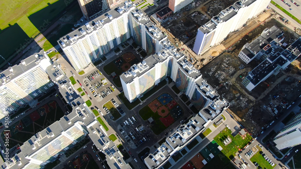 Residential high-rise buildings with of complexes under construction. Motion. Top view of visible contrast of nearby built and populated area