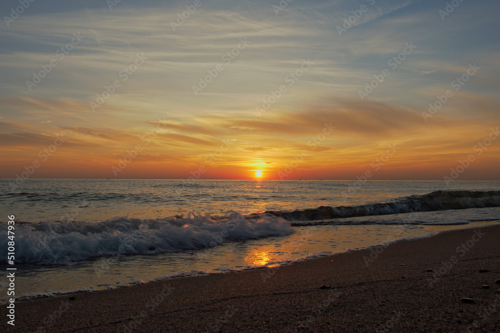 Picturesque Seaside Sunset Shot. Footage of a beautiful seaside sunset scene with waves. Waves splasing neat seashore in the evening