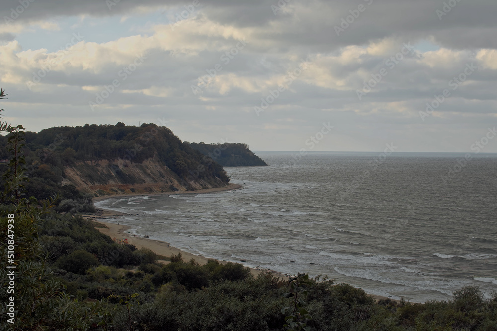 Top view shot, overlooking at Philins bay on a cloudy cold day, in Kaliningrad area, Russia. Panoramic view of cliffs surrounding a bay of water on a cloudy day Top view shot, overlooking at Philins bay on a cloudy cold day, in Kaliningrad area, Russia. Panoramic view of cliffs surrounding a bay of water on a cloudy day