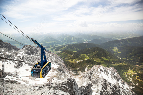Bergpanorama - Seilbahn fährt auf Berg.
Mountain panorama - Cable car drives on mountain. snow on mountain. summer in the valley.