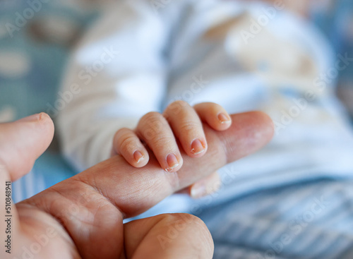 Detail of the fingers of a newborn, especially the nails. Newborn babies have long, sharp nails full of nerve endings. photo