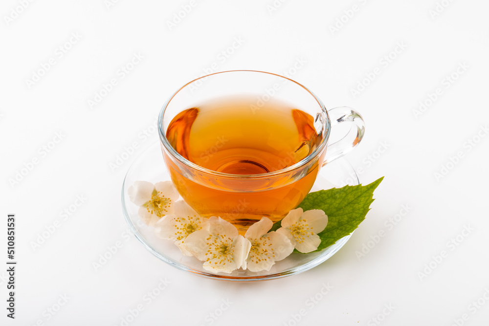 Composition with cup of jasmine tea and flowers on light background Composition with cup of jasmine tea and flowers on light background