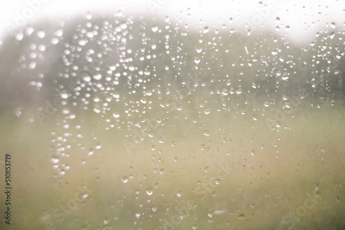 Natural pattern of rain drops on window glass surface.