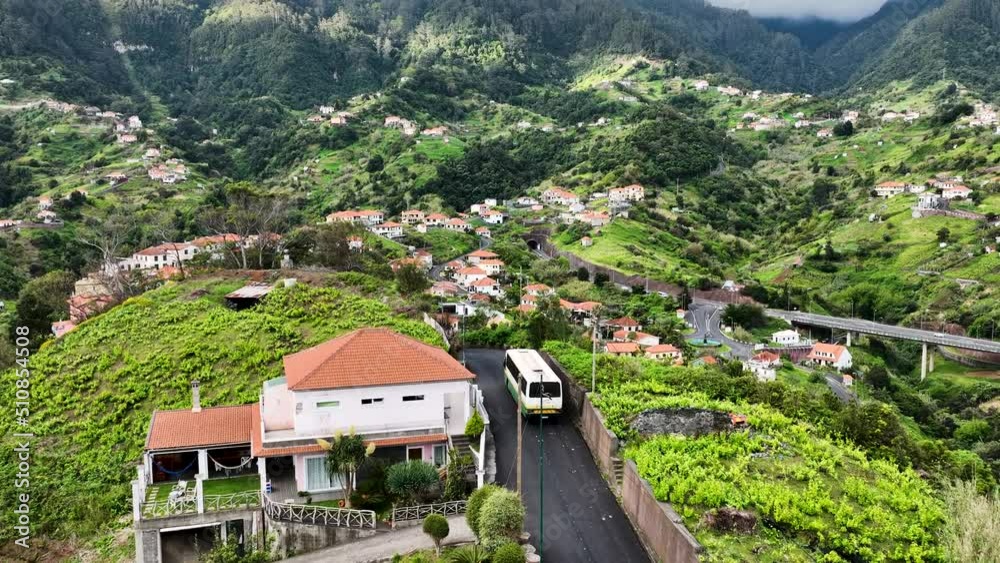 Local bus navigates scenic road in mountainous terrain, Madeira; aerial Local bus navigates scenic road in mountainous terrain, Madeira; aerial