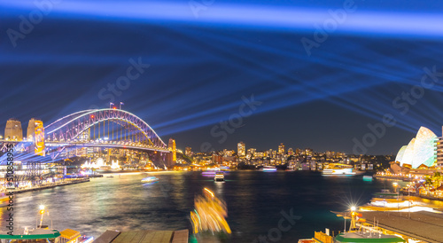 Colourful Light show at night on Sydney Harbour NSW Australia. The bridge illuminated with lasers and neon coloured lights 