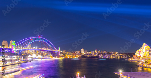 Colourful Light show at night on Sydney Harbour NSW Australia. The bridge illuminated with lasers and neon coloured lights 