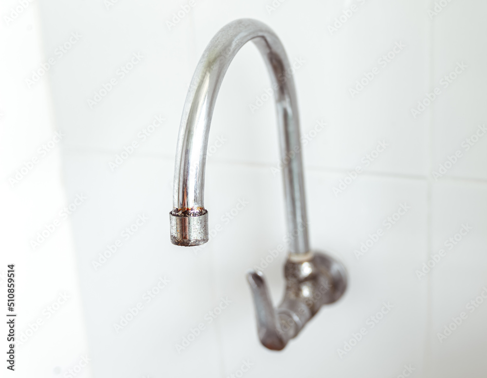 Close up view. Curved shape of old faucet and has rust at the tip. Close up view. Curved shape of old faucet and has rust at the tip.