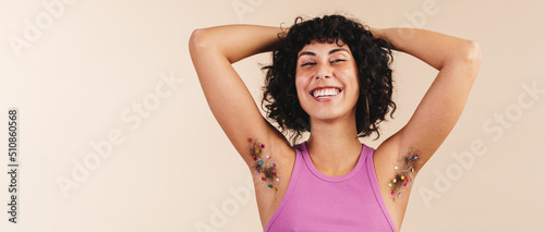 Happy young woman flaunting her decorated underarm hair photo