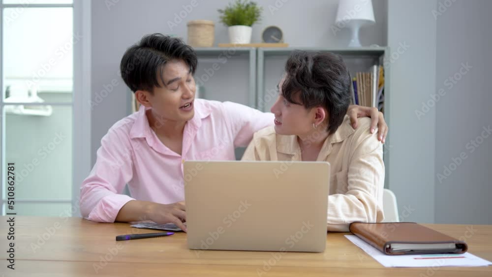 Attractive male lgbtq collegues working together with Looking for additional work on a laptop The boyfriend showed the money he earned from working online. to make decisions faster Attractive male lgbtq collegues working together with Looking for additional work on a laptop The boyfriend showed the money he earned from working online. to make decisions faster