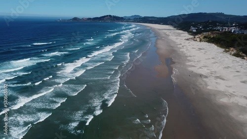 Clockwise drone shot of waves crashing on Nye Beach, a beach in the small town of Newport on the Oregon coast. This 4K cinematic Pacific Northwest scene was filmed using a DJI Mini 2 drone. photo