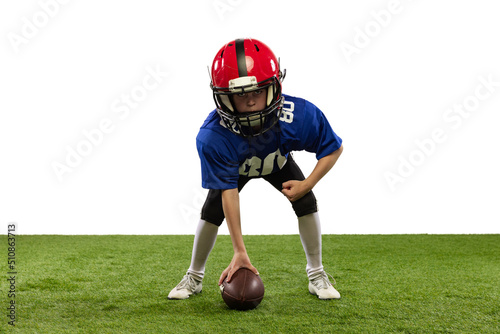 Athletic kid, beginner american football player in sports uniform and helmet training isolated on white background. Concept of sport, challenges, motion, achievements.