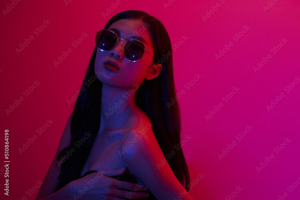 Fashion and beauty concept, Fashion woman with glitter makeup wear sunglasses on neon background Fashion and beauty concept, Fashion woman with glitter makeup wear sunglasses on neon background