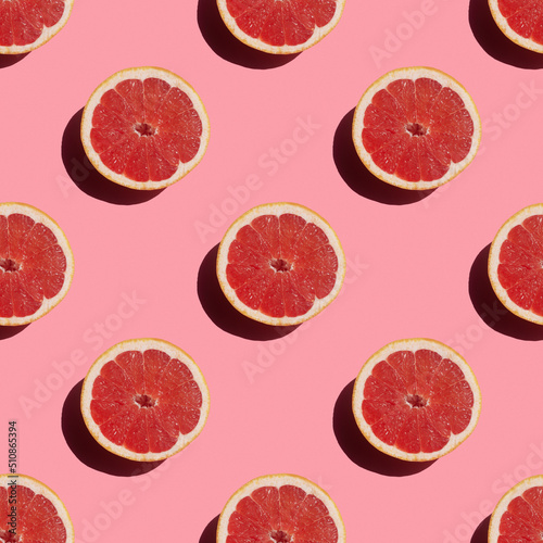 seamless pattern of fresh ripe grapefruit with a shadow on a pink background