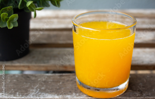 Freshly squeezed and chilled orange juice in a glass over a wooden table