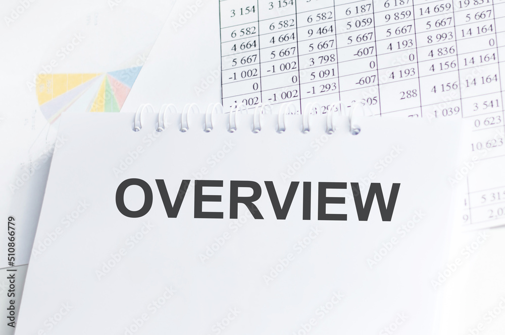 Overview inscription on a notebook on a desk on the background of reports, a business concept Overview inscription on a notebook on a desk on the background of reports, a business concept