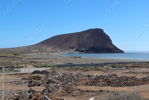 La Tejita beach, El Medano, Tenerife, Spain, March 8, 2022: The quiet and deserted La Tejita beach with the Red Mountain in the background photo
