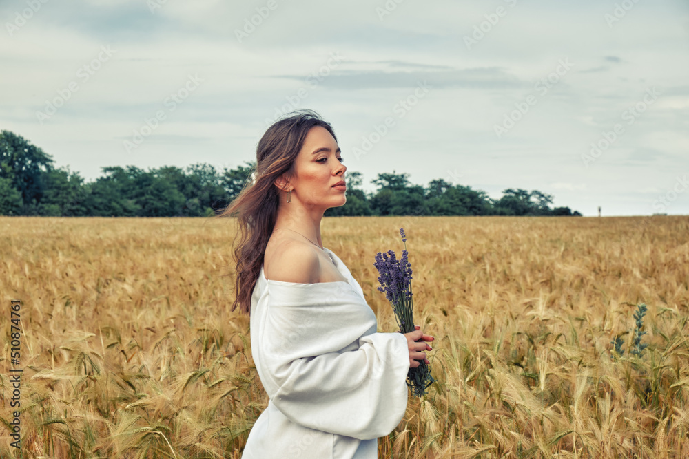 Portrait of a young girl in a field with wheat