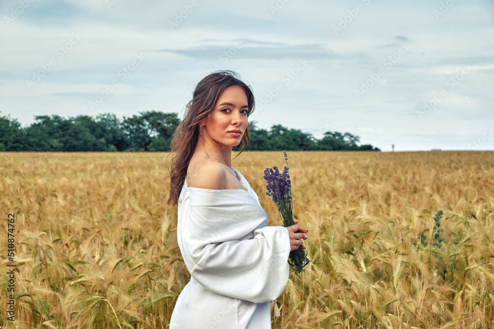 Portrait of a young girl in a field with wheat
