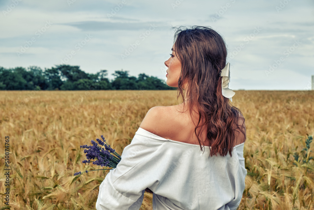 Portrait of a young girl in a field with wheat