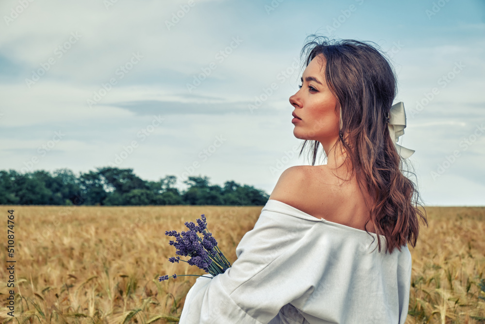 Portrait of a young girl in a field with wheat