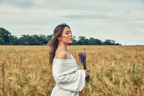 Portrait of a young girl in a field with wheat