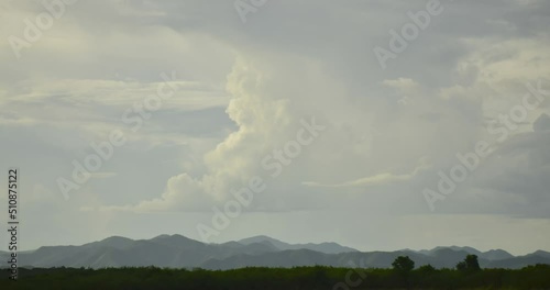 Clouds that were forming in the sky flowed over the top of the mountain.