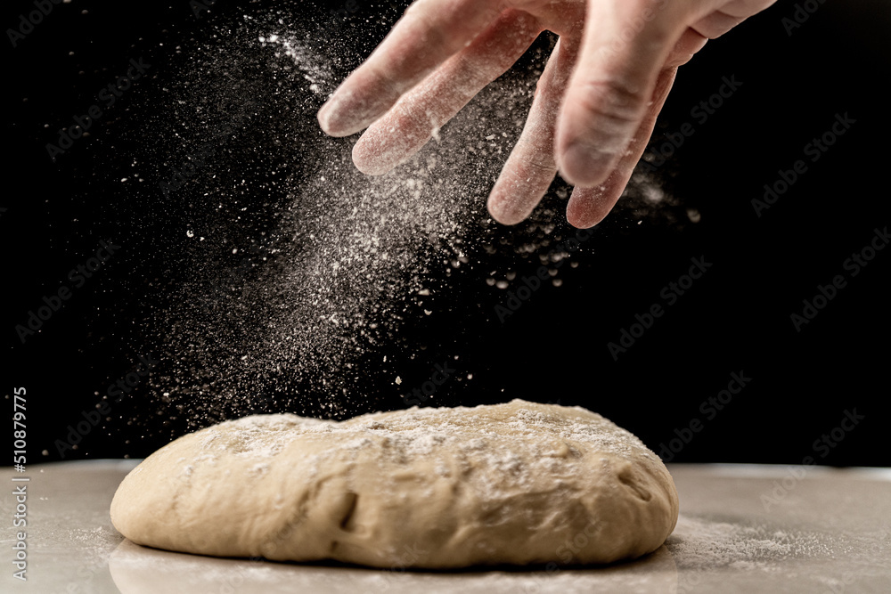 Obraz premium Sprinkling flour on the dough for the preparation of Brioche feuilletée tressée pastry