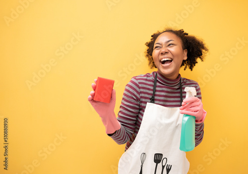 Fotografie African American woman holding bottle chemistry and cloth cleaning house show thumb up