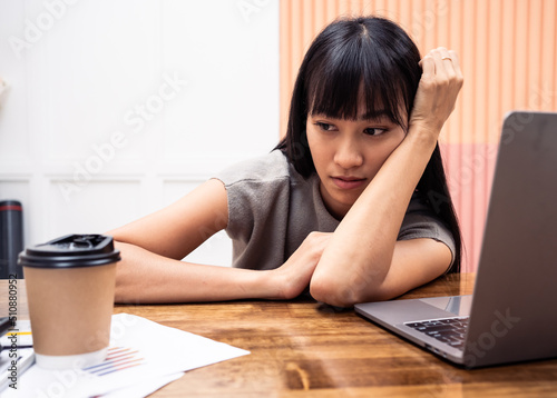 Asian woman stressed while working on laptop.Burnout stressed due to overwork Manager , worker Stressful.Middle life crisis businessman fatigue Sleep on laptop.Depression sadness tension person.