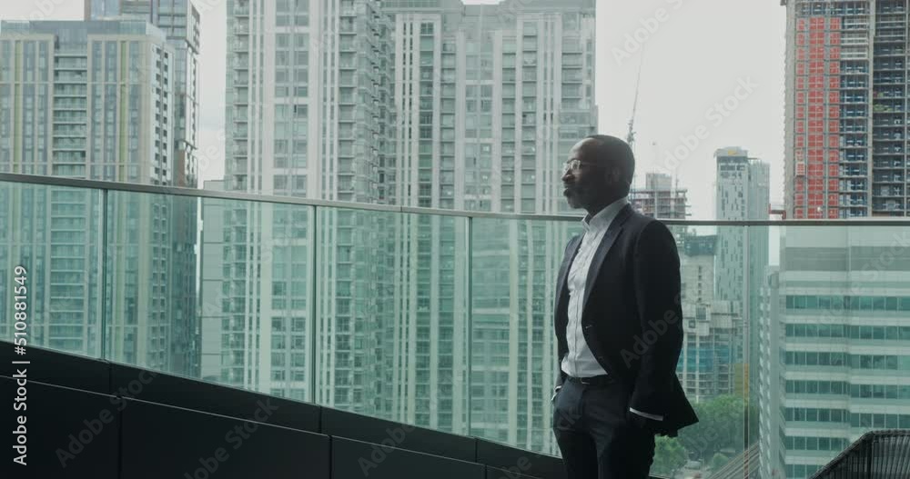 Businessman Standing on Rooftop in City Looking at View