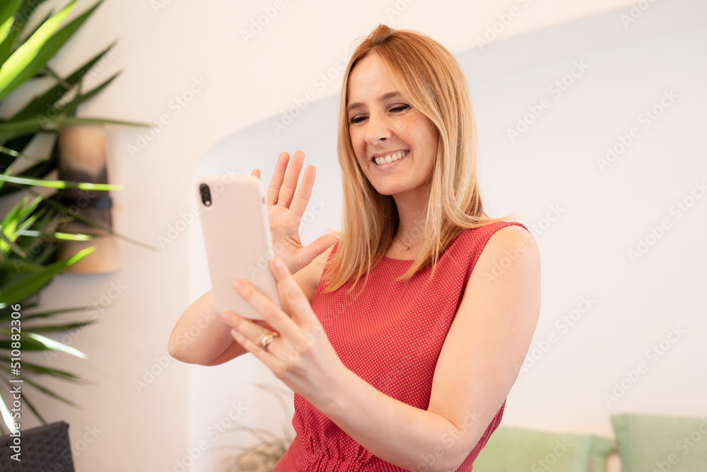 Young happy woman doing video call using smartphone outdoors.