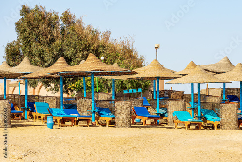 Sandy beach of the Red Sea with a group of straw umbrellas and deck chairs near Marsa Alam  Egypt  Africa. 