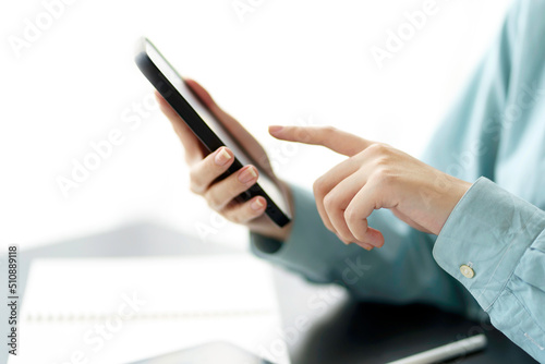 Closeup image of female using smartphone to send text , work or play social media.