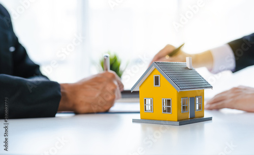 The real estate agent discusses the terms of the home purchase contract and asks the client to sign the documents to legally enter the contract.