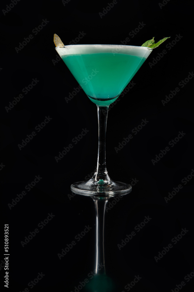 Green cocktail with alcohol. On a black background.
