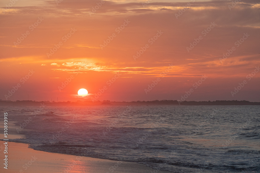 Obraz premium Ocean waves at sunrise off the shore of Cape May , New Jersey USA