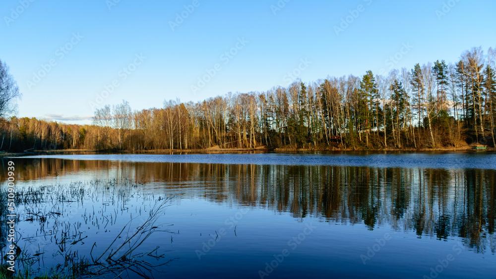 spring landscape with reflections of lakes, clouds and trees on a calm water surface spring landscape with reflections of lakes, clouds and trees on a calm water surface