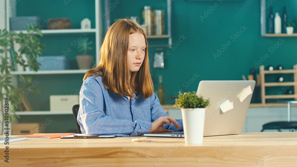 Joyful Red Haired Teenage Girl Studying Online, Comfortable Home Teaching Online in Virtual Classroom Lesson with a Teacher on a Laptop at Home. Education and Homeschooling of Children. Mental Health. Joyful Red Haired Teenage Girl Studying Online, Comfortable Home Teaching Online in Virtual Classroom Lesson with a Teacher on a Laptop at Home. Education and Homeschooling of Children. Mental Health.