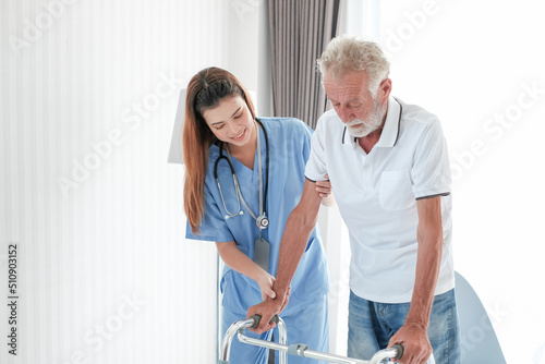 Elderly man with caregiver in nursing home. happy senior man laughing with her caregiver at home The concept of caring for the elderly at home. Nurse talking to disabled and happy grey haired man.